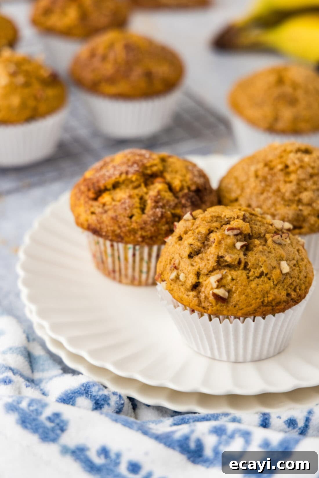 Golden Harvest Pumpkin Banana Muffins 12 Three perfectly baked Pumpkin Banana Muffins arranged on a wire rack, cooling down