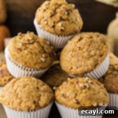 Golden Harvest Pumpkin Banana Muffins 13 Close up photo of a pile of freshly baked Pumpkin Banana Muffins, showing off their texture and golden color