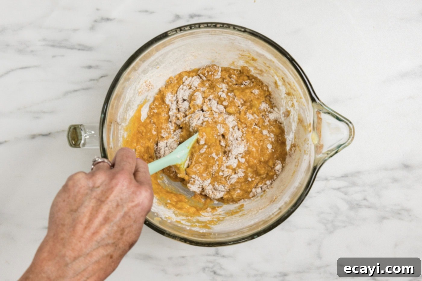 Golden Harvest Pumpkin Banana Muffins 8 Hand gently folding half of the dry ingredients into the pumpkin banana mixture with a rubber spatula