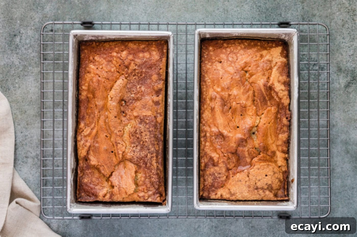 Spiced Apple Cider Pound Cake 11 Freshly baked apple cider pound cakes, golden brown and perfectly risen, resting in their loaf pans.