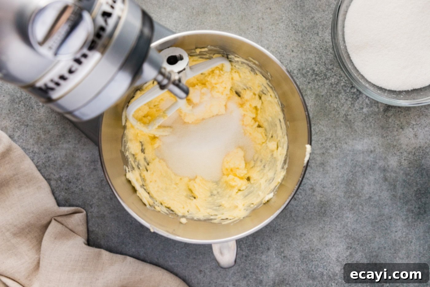 Spiced Apple Cider Pound Cake 6 Granulated sugar being added to the creamy mixture of butter and shortening in a stand mixer bowl.