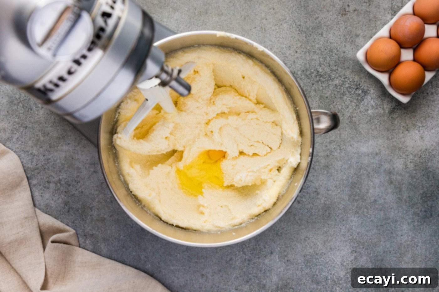 Spiced Apple Cider Pound Cake 7 An egg being carefully added to the butter and shortening mixture in a stand mixer bowl.