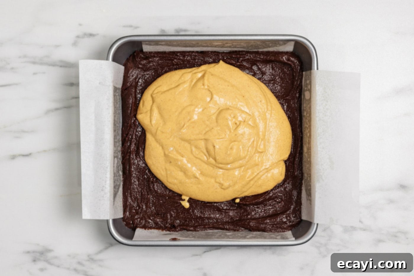 Spiced Pumpkin Cheesecake Swirl Brownies 12 pumpkin cheesecake batter on top of brownie batter in a baking pan