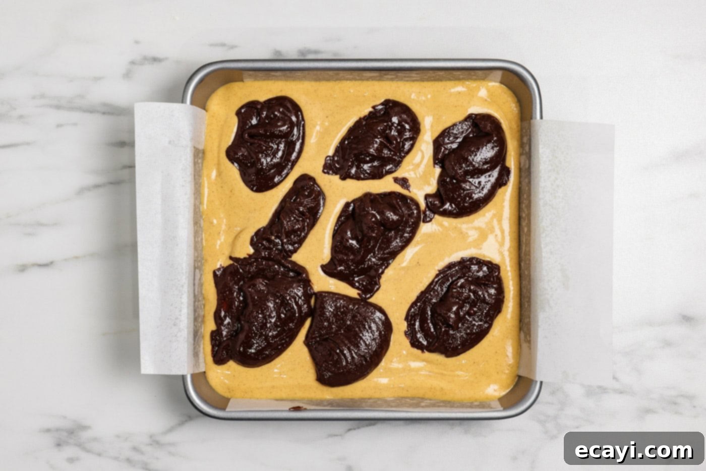 Spiced Pumpkin Cheesecake Swirl Brownies 13 spoonfuls of brownie batter on top of pumpkin cheesecake batter layer in a pan