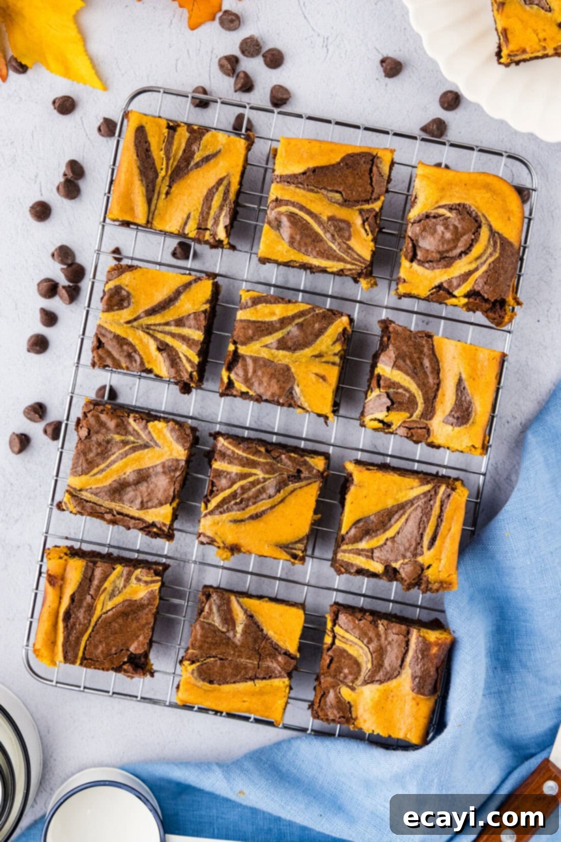 Spiced Pumpkin Cheesecake Swirl Brownies 3 Pumpkin Cheesecake Brownies on a wire rack