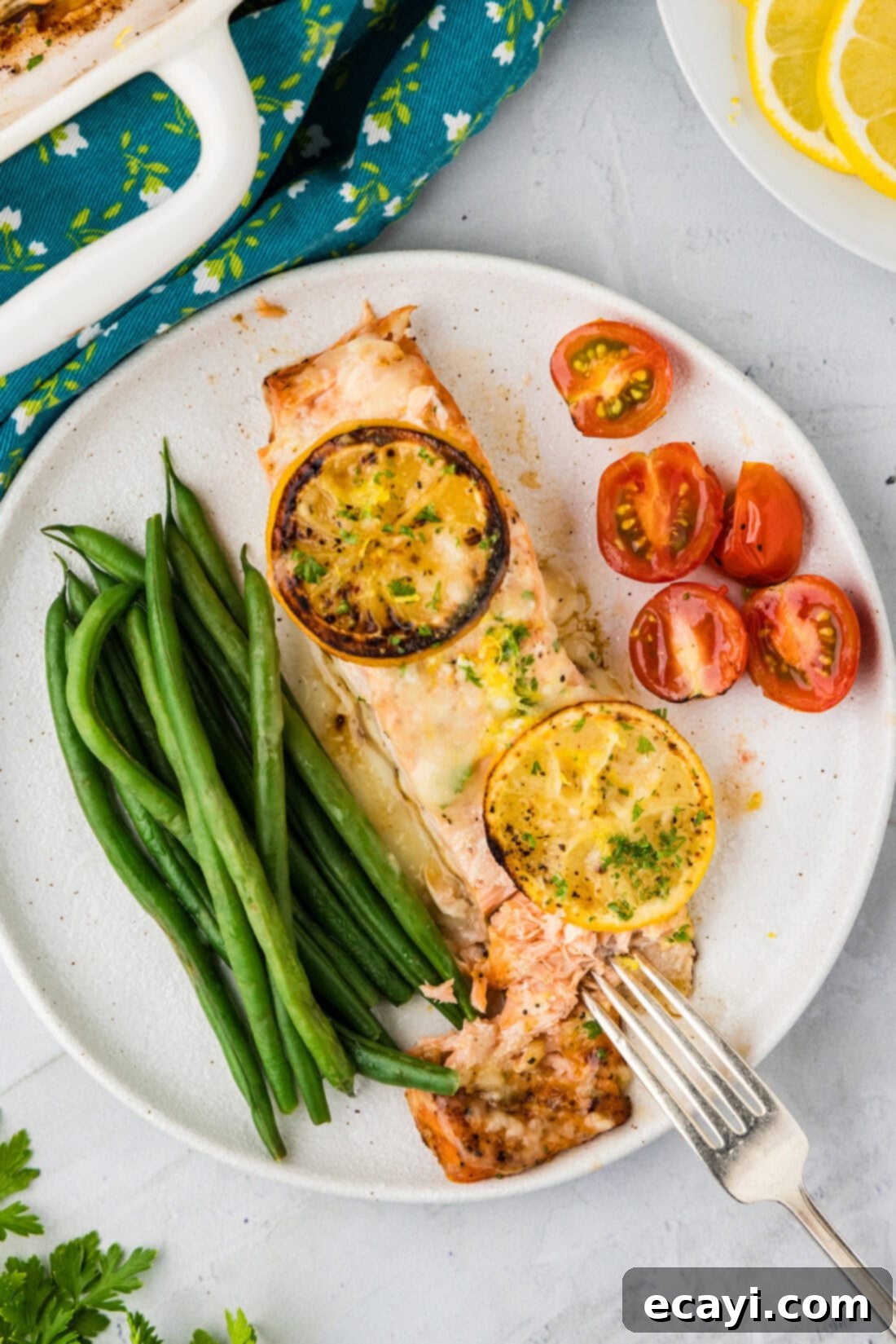 Zesty Lemon Salmon Bake 9 A plated serving of Baked Lemon Salmon, accompanied by vibrant green asparagus and juicy cherry tomatoes, creating a complete and healthy meal.