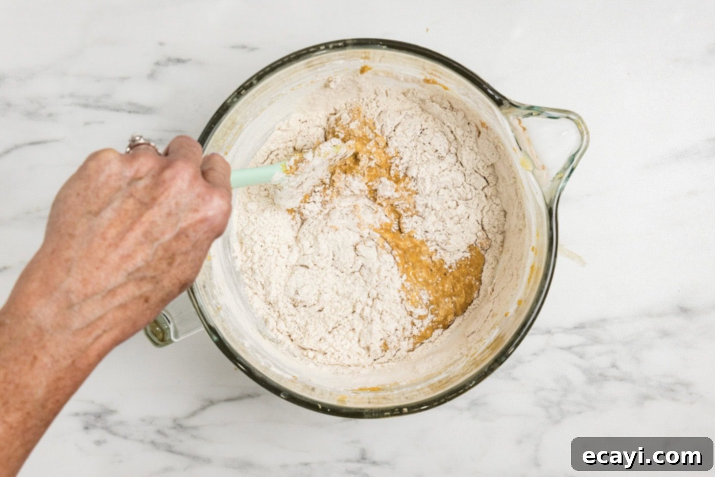 Spiced Pumpkin Banana Loaf 11 folding the rest of the flour into pumpkin batter with a rubber spatula