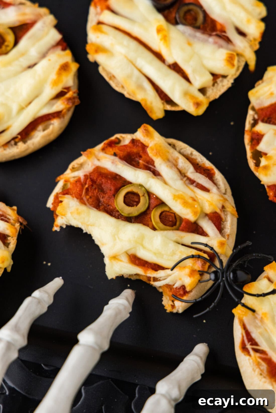 Mummy Mini Pizza Bites 3 Half eaten Mini Mummy Pizza on a black platter