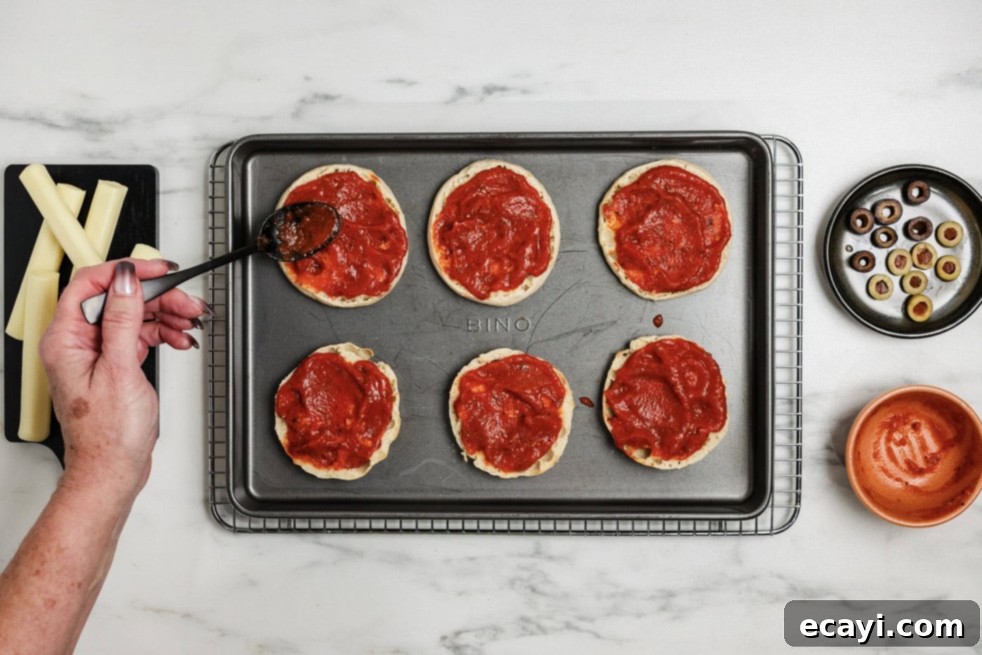 Mummy Mini Pizza Bites 6 basting English muffins with pizza sauce