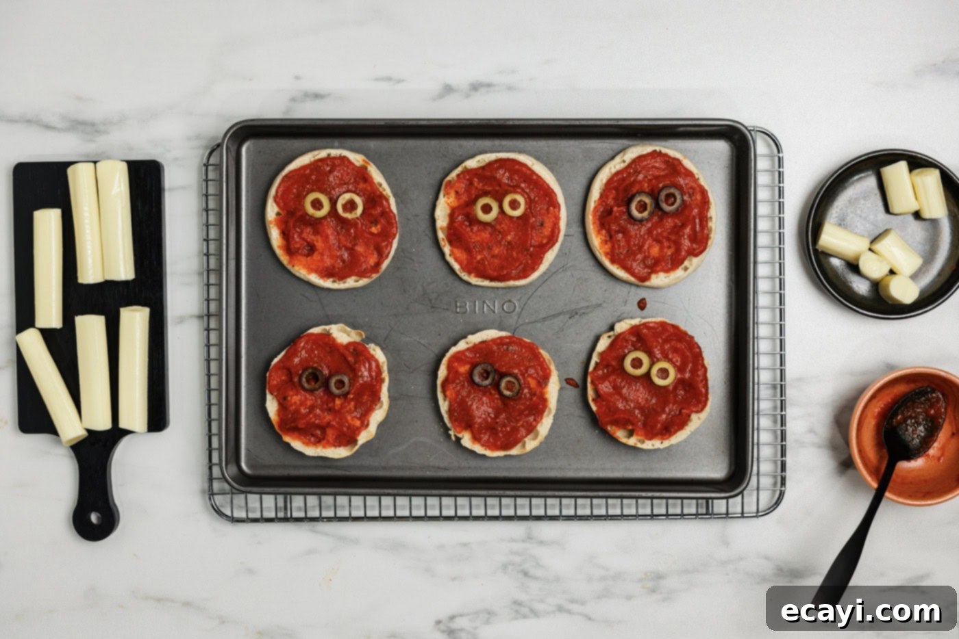 Mummy Mini Pizza Bites 7 Sliced olives placed on top of sauced English muffins to look like eyes