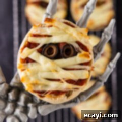 Mummy Mini Pizza Bites 10 Close up photo of a Mini Mummy Pizza in a skeleton hand