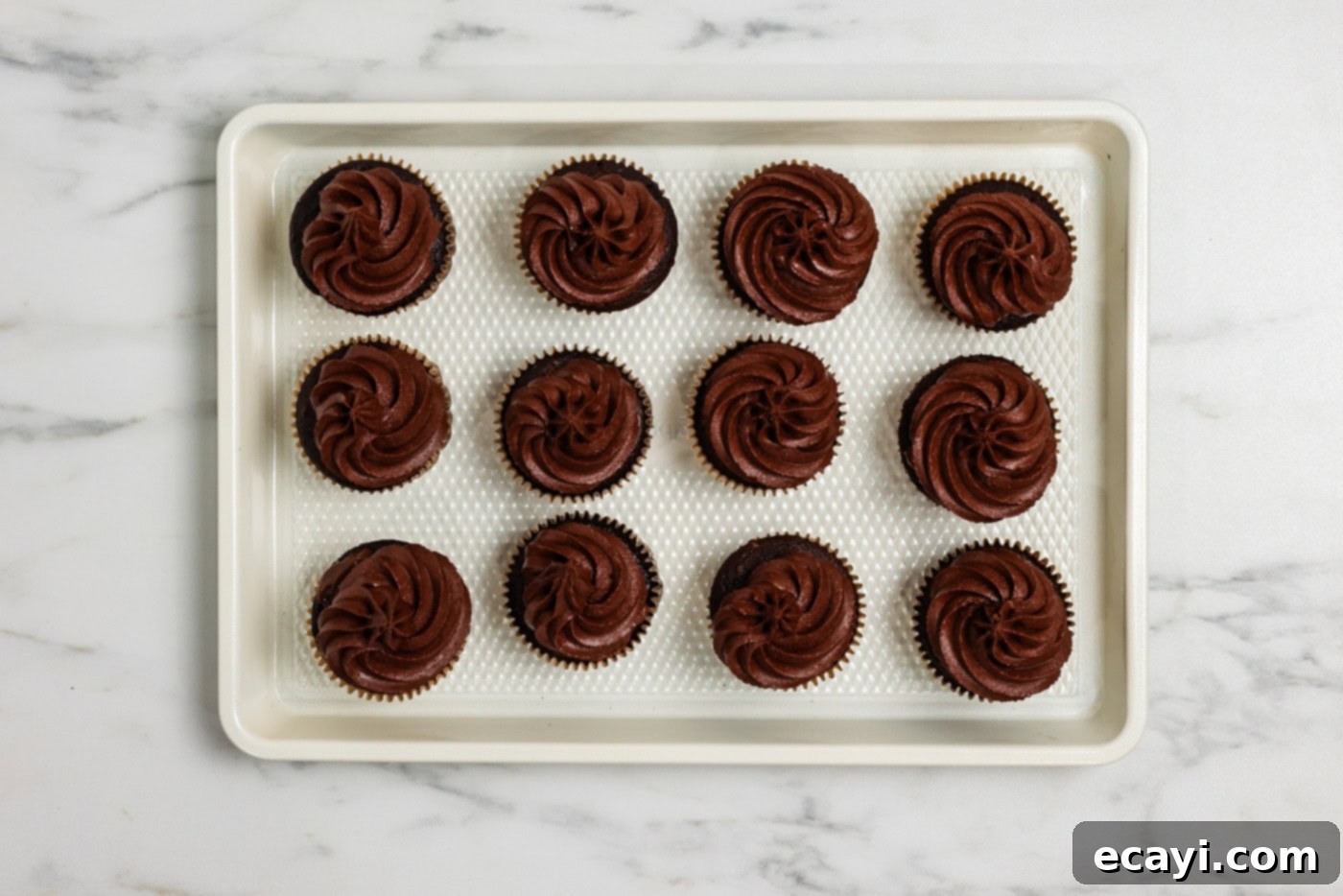Graveyard Crumble Cups 7 Chocolate frosted cupcakes on a baking sheet