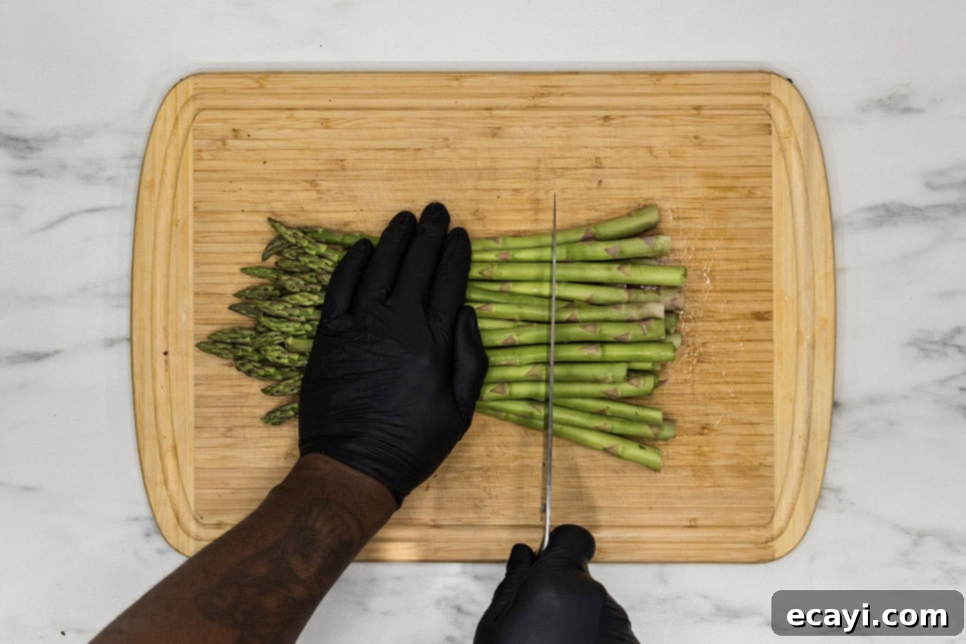 Quick and Tender Instant Pot Asparagus 5 Cutting the woody ends of the asparagus off using a knife on a cutting board