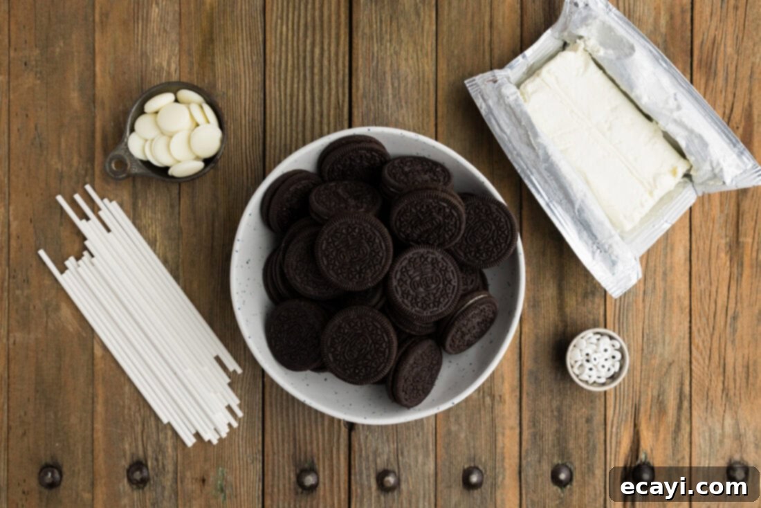 Pharaoh's Pops 4 Ingredients laid out for making Mummy Pops: Oreos, cream cheese, white melting wafers, candy eyeballs