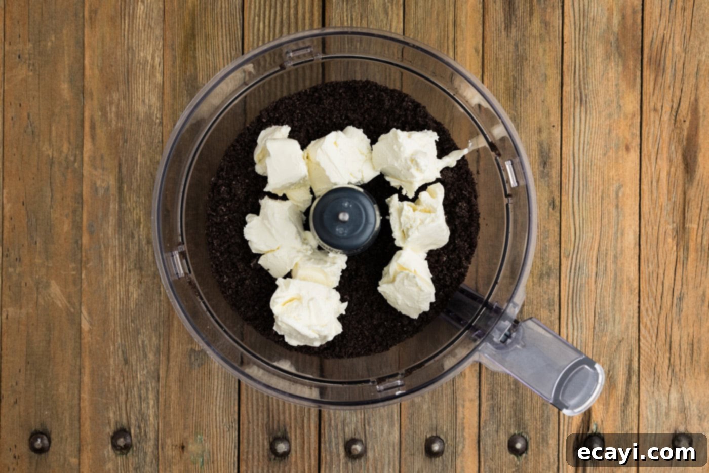 Pharaoh's Pops 6 cubed cream cheese in a food processor bowl along with crumbled Oreos, ready to mix