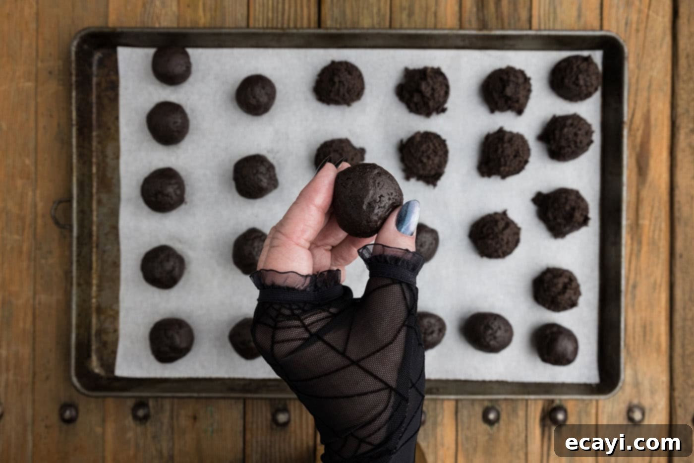 Pharaoh's Pops 9 hand holding a perfectly smooth Oreo truffle ball over a baking sheet