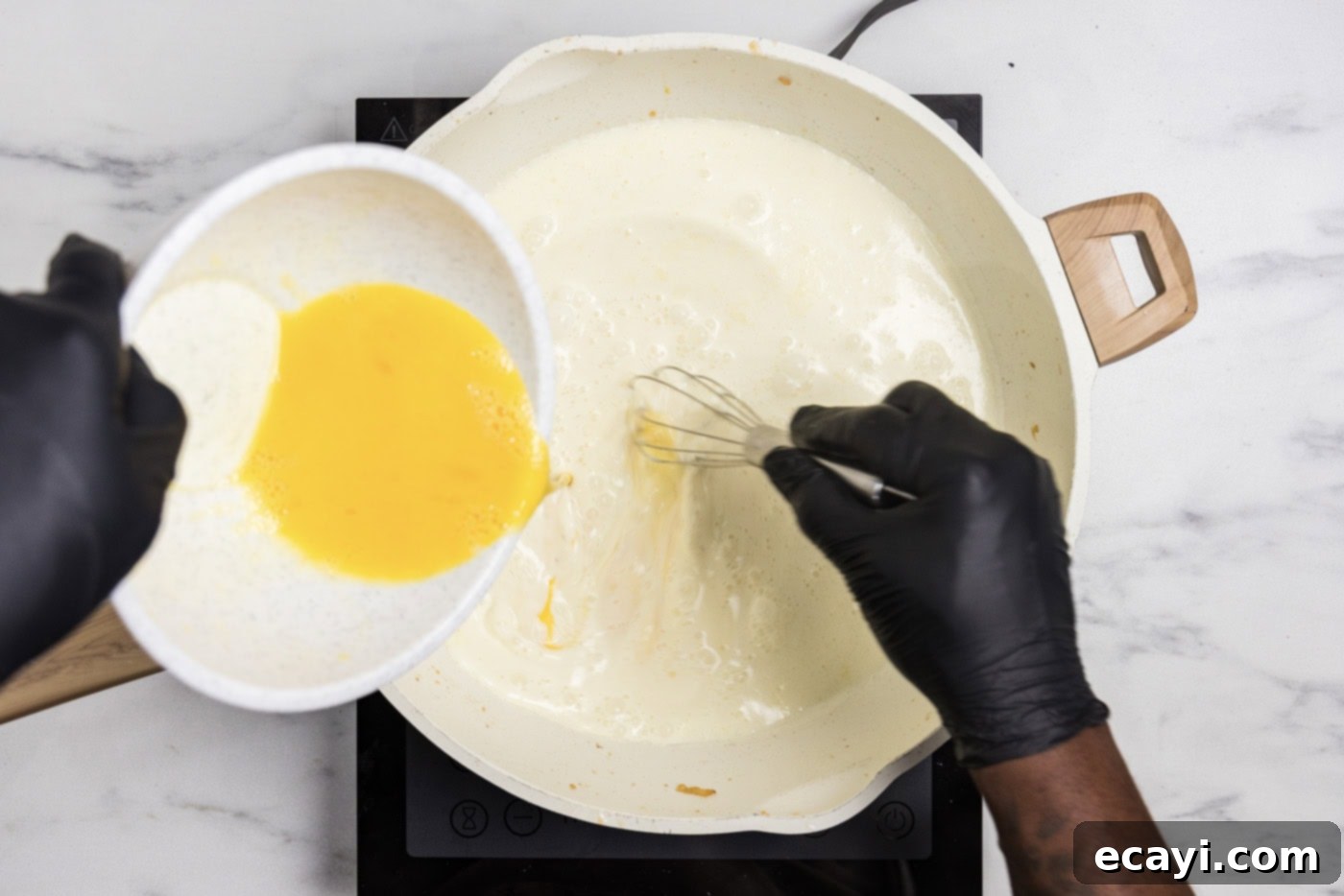 Luscious Chicken Carbonara 8 slowly pouring eggs into cream mixture in a skillet using a whisk