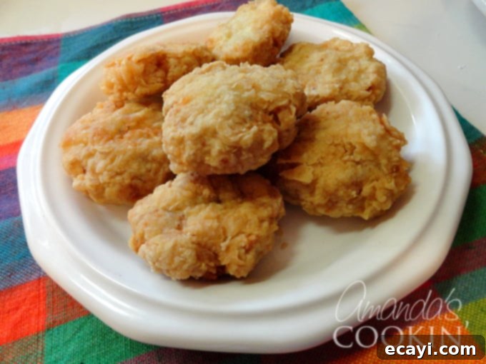 Easy Homemade Chicken Nuggets 3 A beautifully arranged overhead shot of crispy homemade chicken nuggets on a pristine white plate, ready to be served.