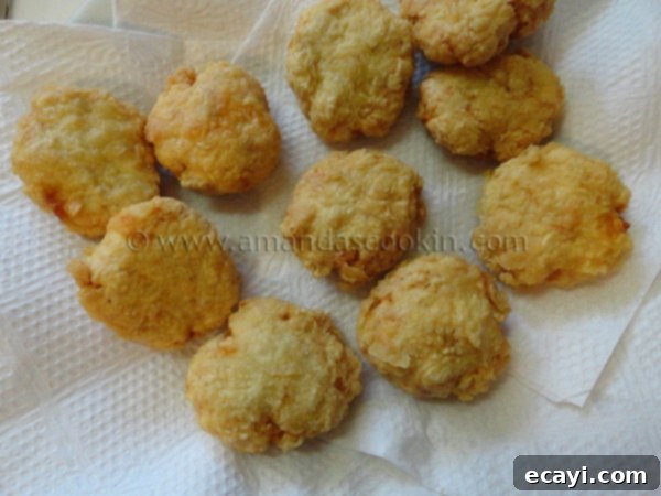 homemade-chicken-nuggets-step-15 An overhead view of freshly fried homemade chicken nuggets resting on a bed of paper towels, absorbing excess oil.