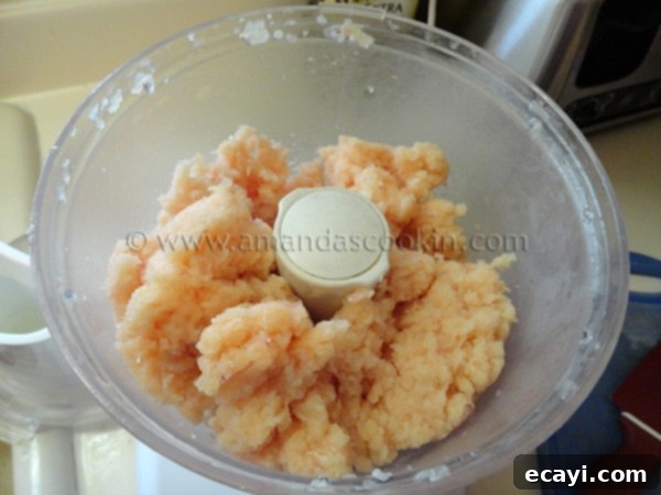 homemade-chicken-nuggets-step-2 A close-up overhead shot of finely processed raw chicken in a food processor bowl, resembling a smooth paste.