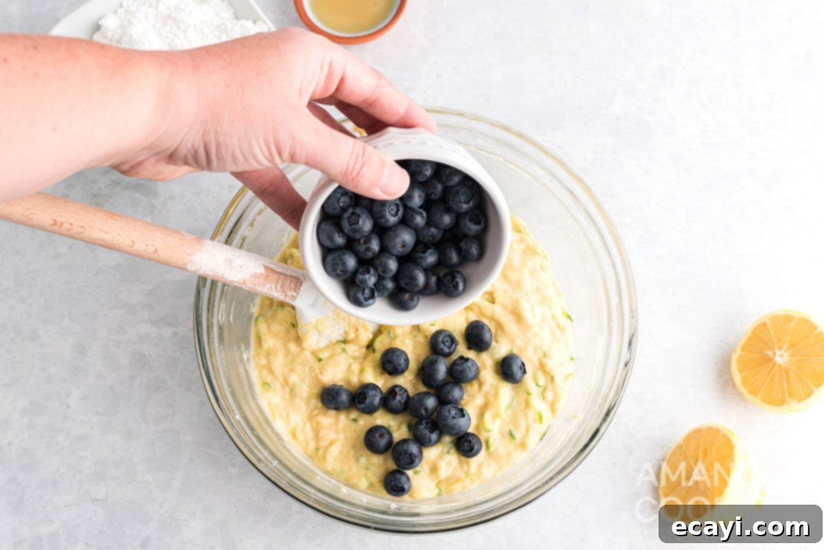 Sweet & Tangy Zucchini Berry Loaf 9 adding blueberries to bowl of batter