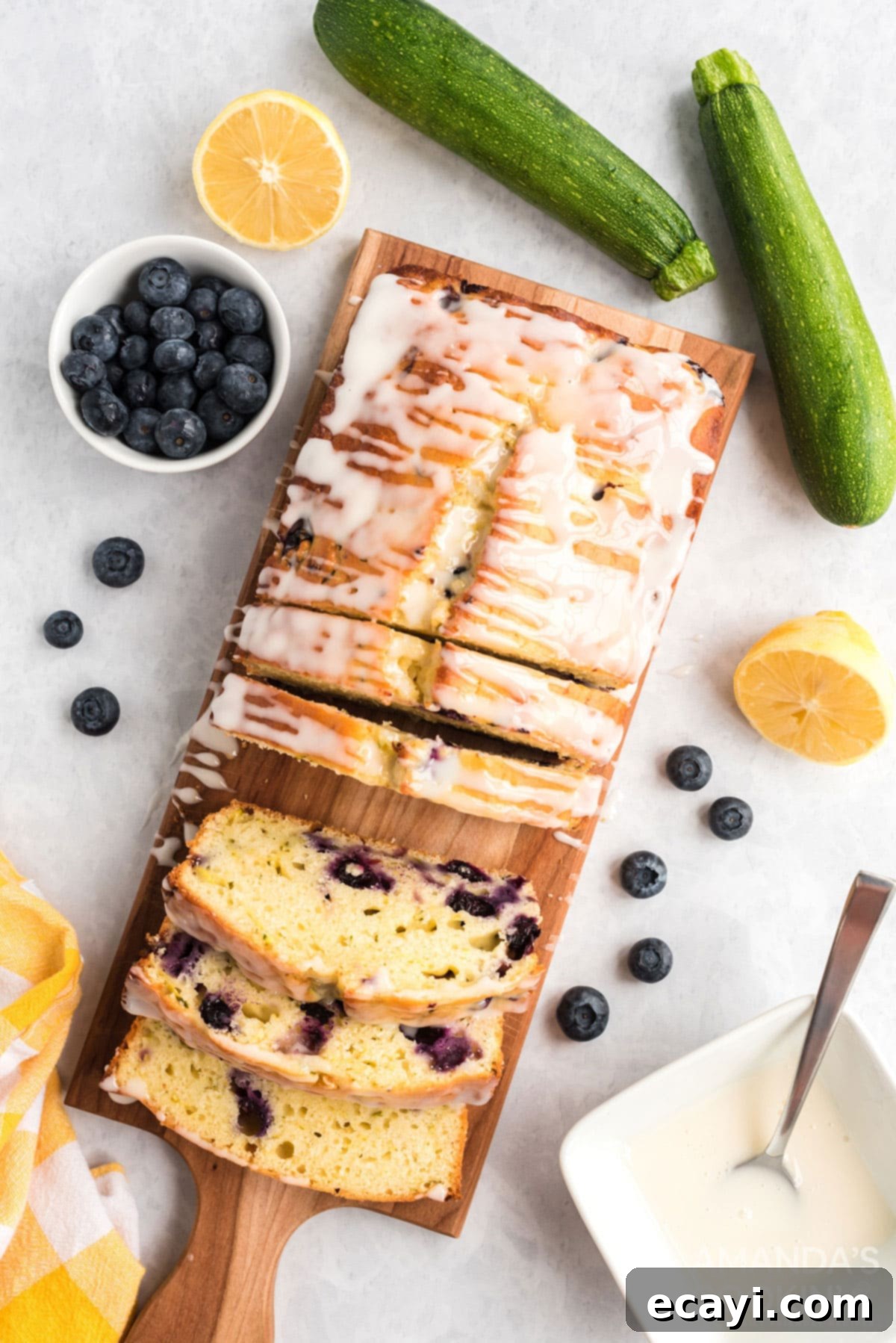Serving Slices of Glazed Lemon Blueberry Zucchini Bread overhead photo of sliced lemon blueberry zucchini bread on a cutting board
