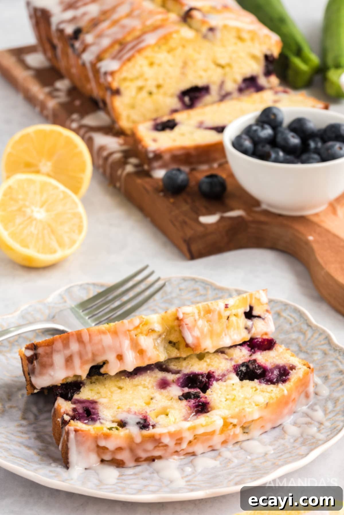 Serving Glazed Lemon Blueberry Zucchini Bread two slices of lemon zucchini bread on a plate