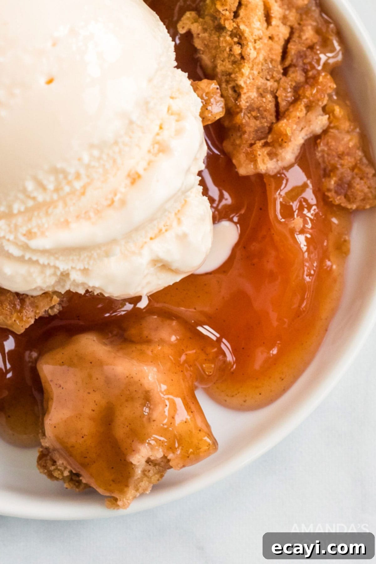 Make crockpot apple cobbler in your slow cooker. This easy crockpot dessert is quick & simple and great any time of year. Close-up shot of the cooked apple cobbler in the crockpot, revealing its texture and rich color.
