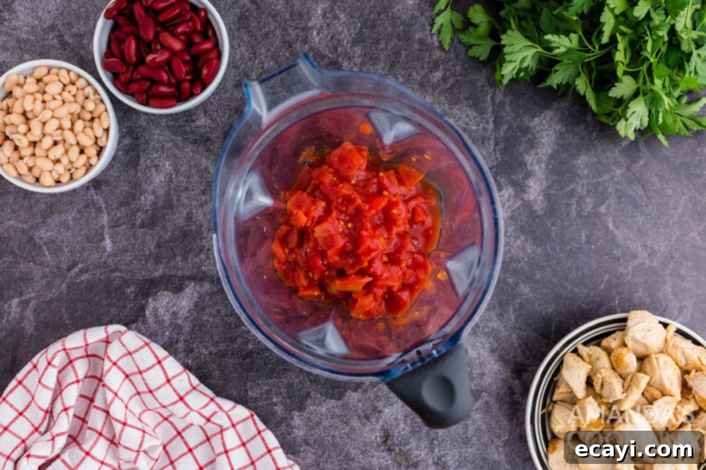 Homestyle Chicken Bean Warmth 8 Canned whole tomatoes being pureed in a food processor to create a smooth, rich tomato base for the soup.