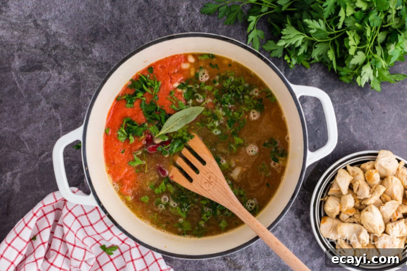 Homestyle Chicken Bean Warmth 9 All the soup ingredients, including pureed tomatoes, broth, beans, parsley, and a bay leaf, simmering together in the Dutch oven.