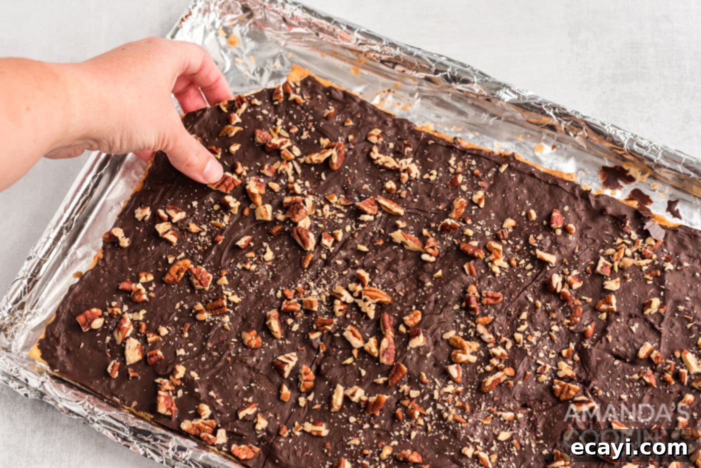 Salty Sweet Toffee Crunch 13 hand breaking off a piece of saltine toffee