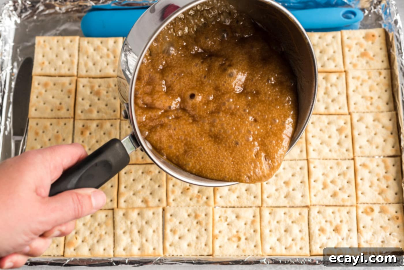 Salty Sweet Toffee Crunch 8 pouring caramel over saltine crackers