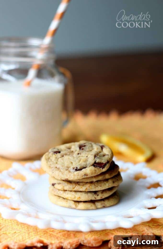 Citrus-Kissed Chocolate Chip Treats 2 A stack of perfectly baked orange chocolate chip cookies on a white plate, ready to be enjoyed.