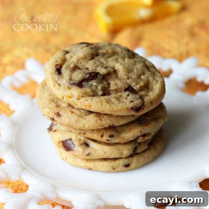 Citrus-Kissed Chocolate Chip Treats 4 A perfectly arranged stack of orange chocolate chip cookies on a pristine white plate, showcasing their inviting golden color.