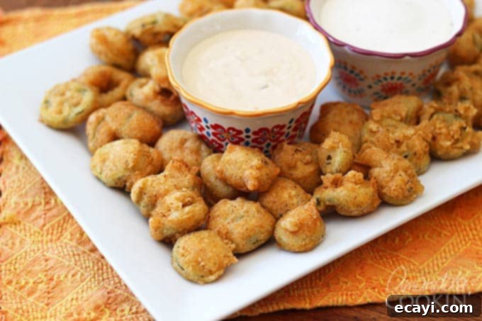 Crispy Fried Jalapeno Bites 4 A plate of crispy fried jalapeno slices served with dipping sauce.