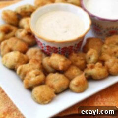 Crispy Fried Jalapeno Bites 8 A close up photo of a plate of crispy fried jalapeno slices served with a bowl of dipping sauce.