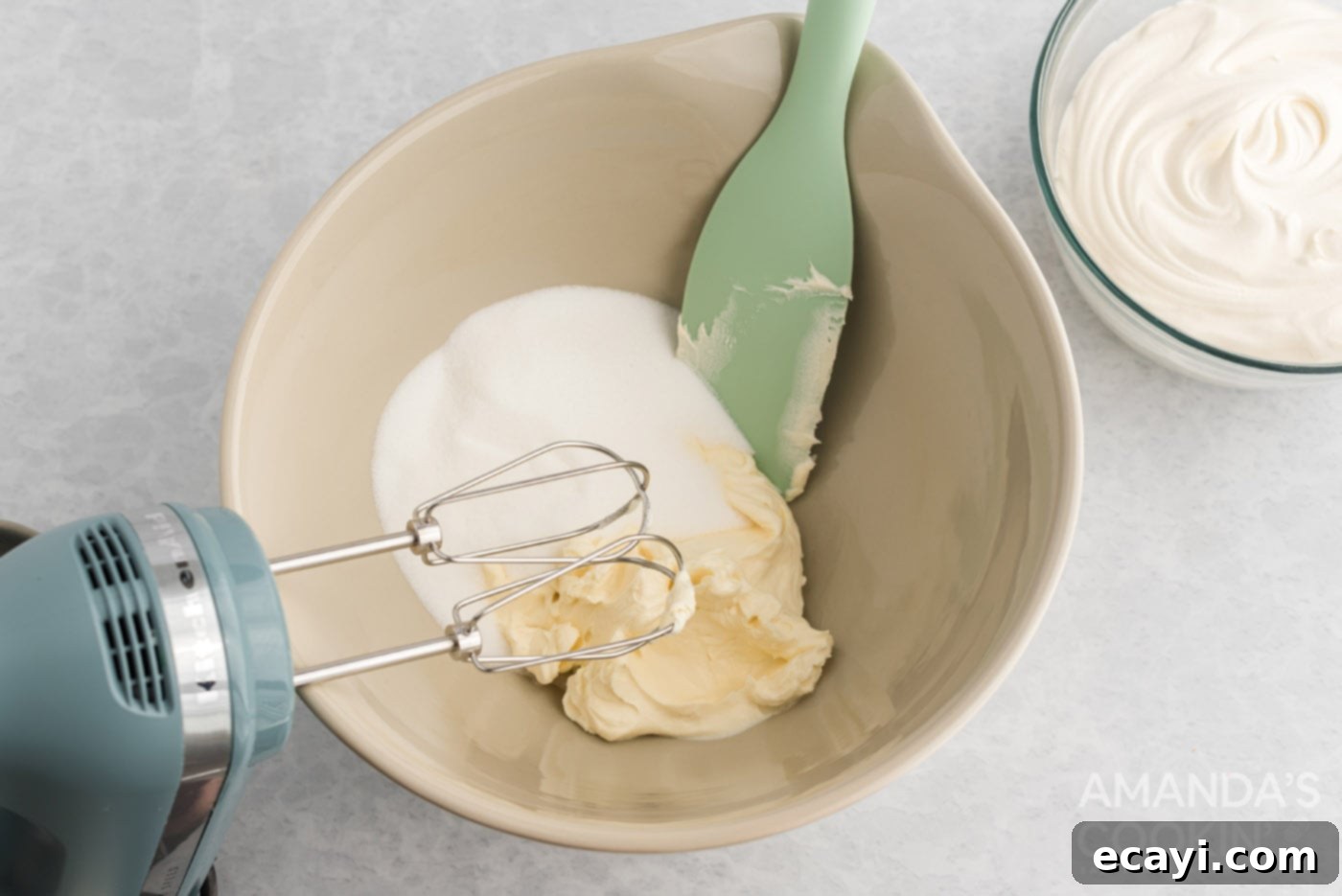Strawberry Pretzel Delight 10 Sugar and softened cream cheese being mixed together in a bowl until smooth and creamy.