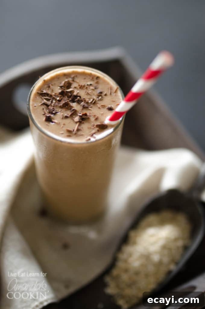 Coffee Smoothie: Quick, Healthy, and Delicious. Close-up of a refreshing coffee smoothie in a clear glass with a red and white striped straw, highlighting its smooth, thick texture and inviting appearance. A hint of a cozy morning setting is visible in the background.