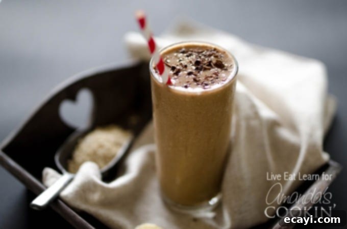 Smooth and Delicious Coffee Smoothie. A vibrant and smooth loaded coffee smoothie served in a clear glass with a stylish paper straw, ready to be enjoyed. The visual emphasizes its readiness and appealing texture.