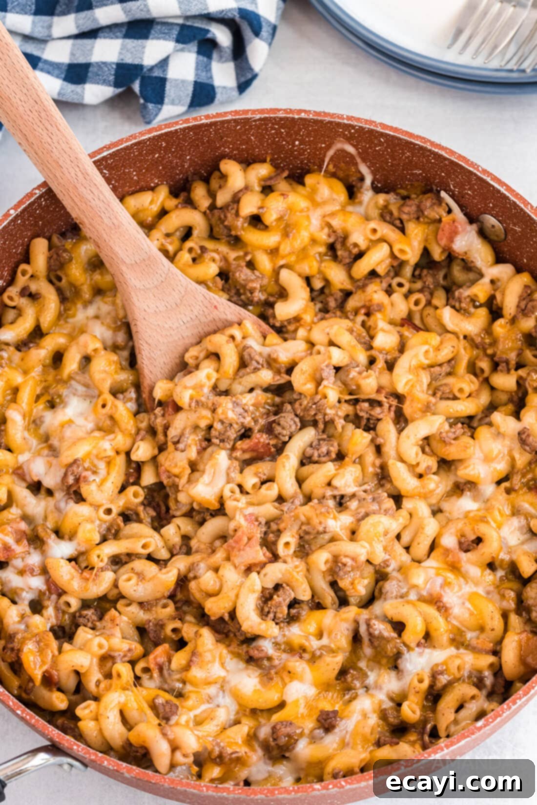 Ultimate Bacon Cheeseburger Bake 3 A large cast iron skillet filled with a bubbling, cheesy bacon cheeseburger casserole, topped with melted cheese.