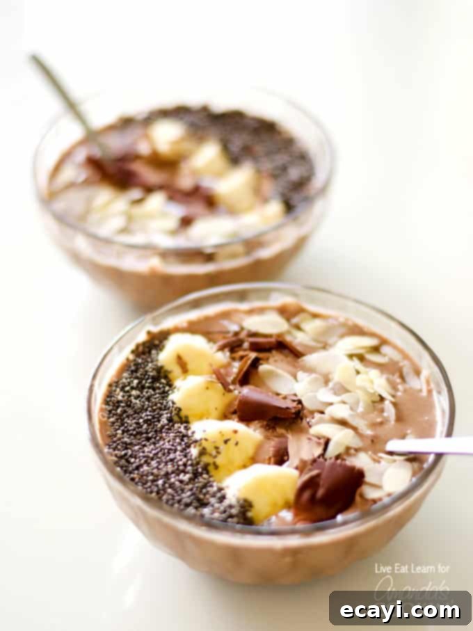 Dreamy Mocha Smoothie Bowl 3 A close up of two mocha smoothie bowls topped with sliced banana, shaved chocolate and sliced almonds, ready to be eaten.