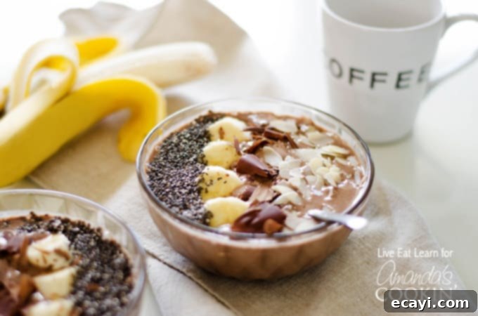 Dreamy Mocha Smoothie Bowl 4 A close up of a single mocha smoothie bowl topped with sliced banana, shaved chocolate and sliced almonds, ready for a spoon.