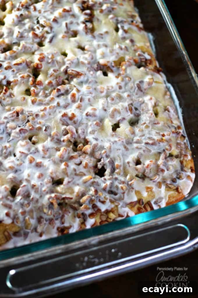 Learn how to make this super simple Pistachio Poke Cake that is always a crowd please. Pistachio Poke Cake is great as a take-along dessert for potlucks! Overhead shot of a freshly baked Pistachio Poke Cake in a 9x13 inch baking pan, ready for the glaze.