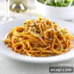 Sun-Kissed Tomato Pesto 5 A photo of sun dried tomato pesto on pasta on a white plate.