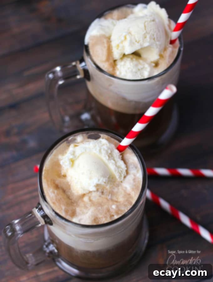 Spiked Root Beer Float 3 An overhead photo of two root beer float cocktails in clear mugs served with a red and white striped straw.