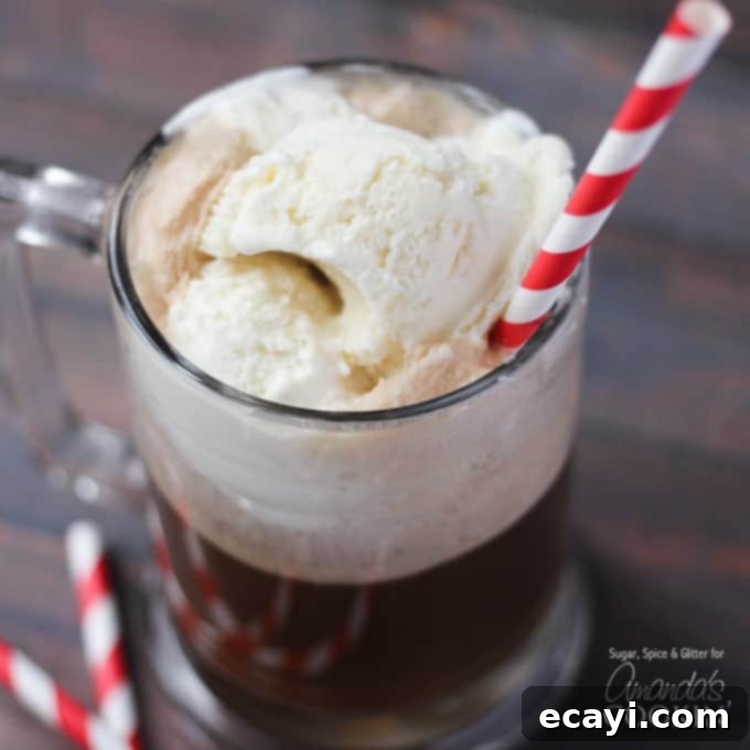 Spiked Root Beer Float 5 A photo of a root beer float cocktail in a clear mug served with a red and white striped straw.