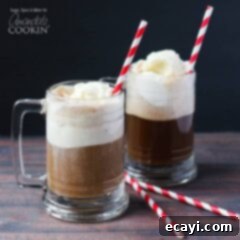 Spiked Root Beer Float 6 A photo of two root beer float cocktails in clear mugs served with a red and white striped straw.