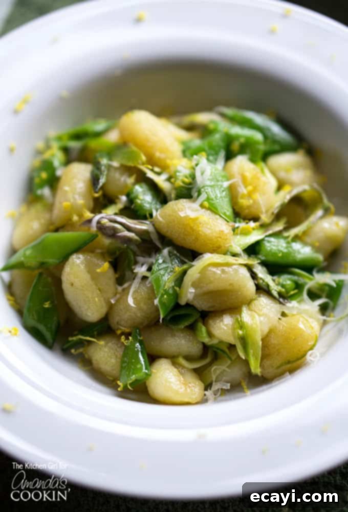 Golden Pan-Seared Gnocchi with Asparagus Ribbons and Sweet Snap Peas 5 A close up overhead photo of pan seared gnocchi with shaved asparagus and snap peas in a white bowl.