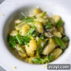 Golden Pan-Seared Gnocchi with Asparagus Ribbons and Sweet Snap Peas 6 A close up overhead photo of pan seared gnocchi with shaved asparagus and snap peas in a white bowl.