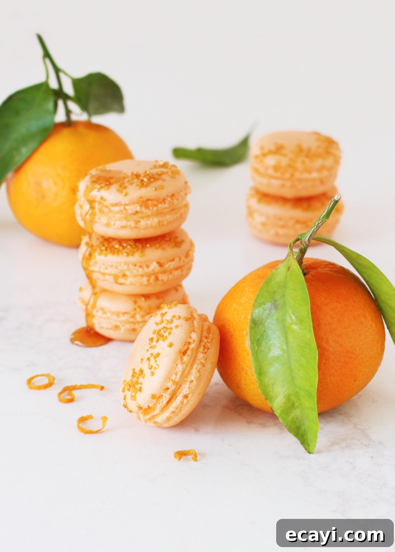 Luscious Honey Orange French Macarons 2 Delicate Honey Orange French Macarons on a plate, featuring a vibrant orange color and golden sprinkles